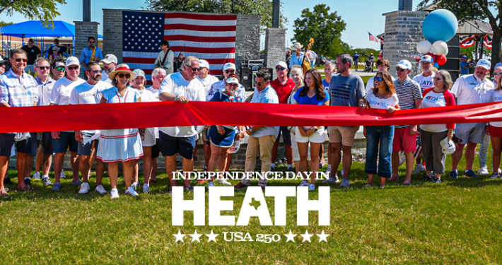 Community members gather for a ribbon-cutting ceremony celebrating the newly renovated Towne Center Park in Heath, Texas, during the city's Independence Day festivities. A large American flag hangs in the background as officials and residents stand behind a wide red ribbon, with patriotic decorations, balloons, and cheerleaders on either side. The image includes the text: "Independence Day in Heath – USA 250.