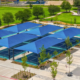 An aerial shot of Towne Center Park looking over the blue shade covers of the pickleball court.