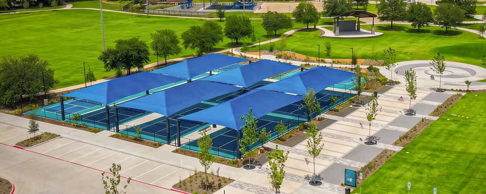 An aerial shot of Towne Center Park looking over the blue shade covers of the pickleball court.