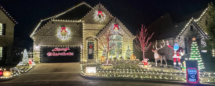 A beautiful 2 story house lit up with hundreds of Christmas LIghts.