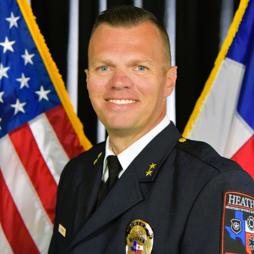 Headshot of Heath DPS Chief Brandon Seery standing in front of the US and Texas flags.