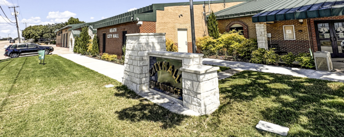 A stone monument sign in front of City Hall.
