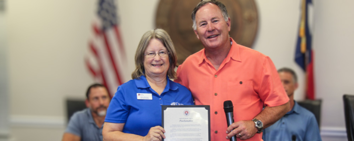 Resident Becky Burkett accepts the proclamation from Mayor Elam.