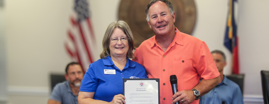 Resident Becky Burkett accepts the proclamation from Mayor Elam.