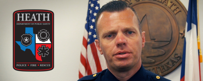 Heath DPS Chief Brandon Seery standing in front to the City of Heath seal at City Hall.
