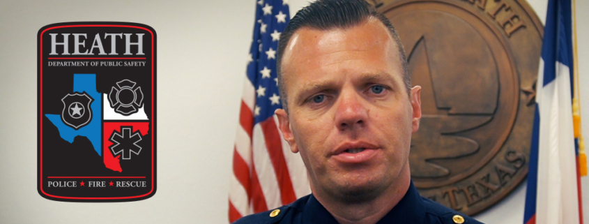 Heath DPS Chief Brandon Seery standing in front to the City of Heath seal at City Hall.