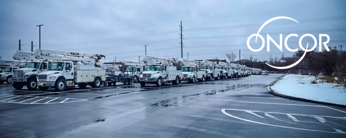 A long row of white Oncor utility bucket trucks parked in a wet lot on an overcast winter day, with patches of snow along the edges and the Oncor logo displayed in the upper right.