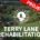 An aerial view of a lush, green residential neighborhood featuring scattered houses and roads. Superimposed in the center is the white circular seal for the City of Heath, Texas, which includes a sailboat motif surrounded by stars. Below the seal, large white text reads "TERRY LANE REHABILITATION". A prominent red diagonal banner stretches across the top right corner with bold white text that says "PROJECT COMPLETED".
