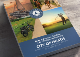 Stack of FY2025-2026 Budget documents on a wooden table.